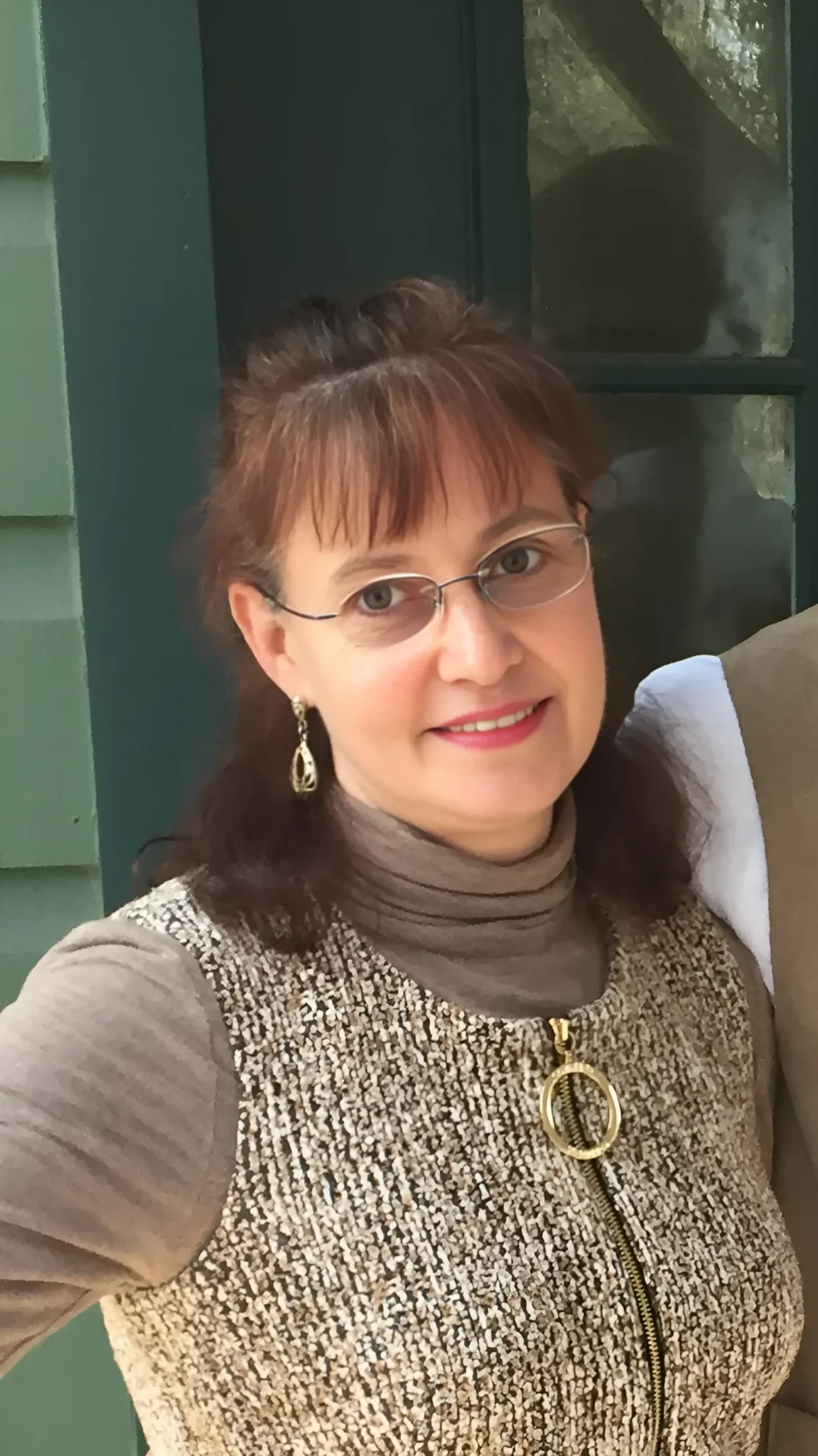 Smiling woman wearing glasses and pendant